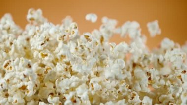 Renkli arka plan üzerine düşen patlamış mısır Süper yavaş hareket. Yüksek hızlı sinema kamera, 1000fps filme.