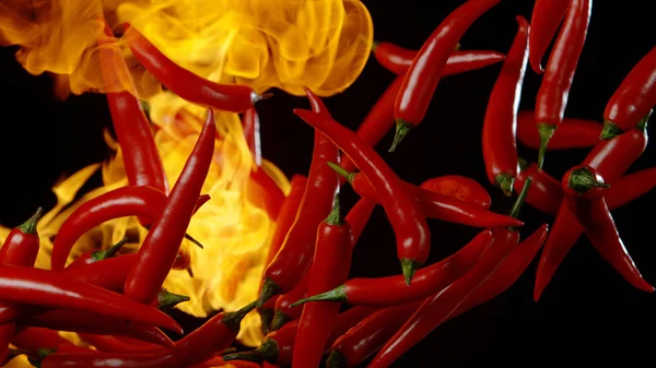 Fliegende rote Chilischoten mit Flammen — Stockfoto