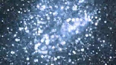 Siyah arkaplanda ışıldayan mavi parçacıkların süper yavaş çekimi. Sığ odak derinliği. Yüksek hızlı sinema kamerası, 1000 fps..