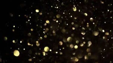 Siyah zemin üzerinde ışıldayan altın parçacıkların süper yavaş çekimi. Sığ odak derinliği. Yüksek hızlı sinema kamerası, 1000 fps..