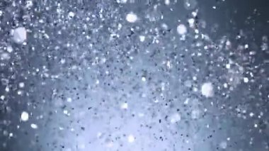 Siyah arkaplanda ışıldayan mavi parçacıkların süper yavaş çekimi. Sığ odak derinliği. Yüksek hızlı sinema kamerası, 1000 fps..