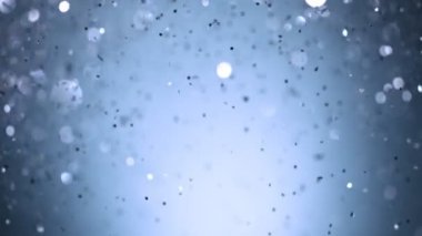 Siyah arkaplanda ışıldayan mavi parçacıkların süper yavaş çekimi. Sığ odak derinliği. Yüksek hızlı sinema kamerası, 1000 fps..