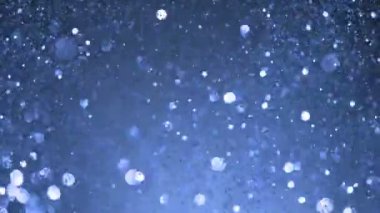 Siyah arkaplanda ışıldayan mavi parçacıkların süper yavaş çekimi. Sığ odak derinliği. Yüksek hızlı sinema kamerası, 1000 fps..