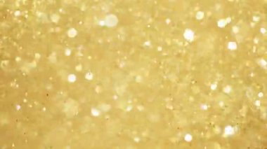 Siyah zemin üzerinde ışıldayan altın parçacıkların süper yavaş çekimi. Sığ odak derinliği. Yüksek hızlı sinema kamerası, 1000 fps..