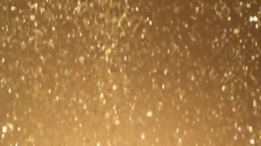 Siyah zemin üzerinde ışıldayan altın parçacıkların süper yavaş çekimi. Sığ odak derinliği. Yüksek hızlı sinema kamerası, 1000 fps..