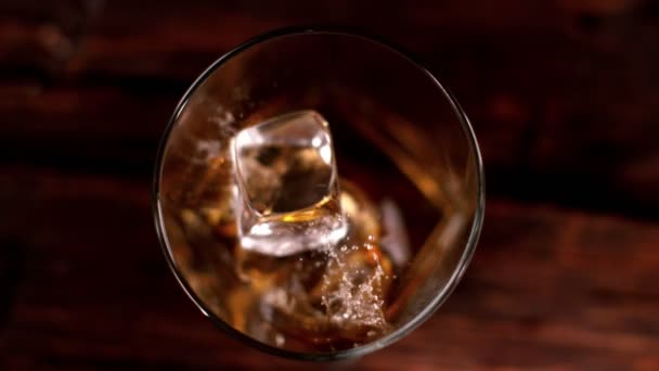 Super Slowmotion Van Dalende Ijsblokje Whisky Glas Bovenaanzicht Gefilmd Cinema — Stockvideo