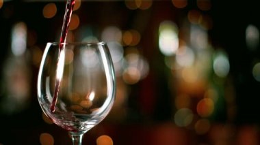 Şişeden kadehe kırmızı şarap dökme süper yavaş hareket. Yüksek hızlı sinema kamera 1000fps filme.