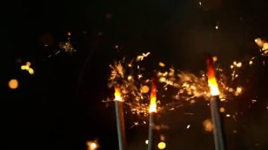 Siyah arka planda yanan kıvılcımların süper yavaş hareketi. Yüksek hızlı sinema kamera, 1000fps filme.