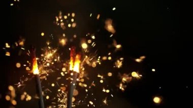 Siyah arka planda yanan kıvılcımların süper yavaş hareketi. Yüksek hızlı sinema kamera, 1000fps filme.