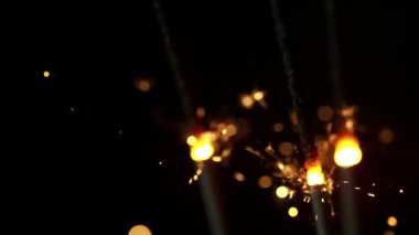 Siyah arka planda yanan kıvılcımların süper yavaş hareketi. Yüksek hızlı sinema kamera, 1000fps filme.