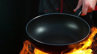 Şefin alevlerle dolu boş tavayı tutuşu çok yavaş. Yüksek hızlı sinema kamerası, 1000fps.