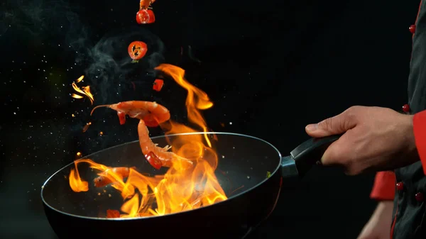 Primer plano del chef sosteniendo la sartén wok con gambas caídas — Foto de Stock