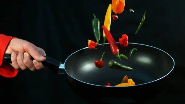 Primer plano del chef sosteniendo freír con chiles cayendo — Foto de Stock