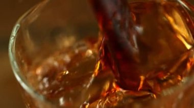 Viski, rom ya da kolayı bardağa doldururken süper yavaş çekim. Süper makro shot. Yüksek hızlı sinema kamerası, 1000fps