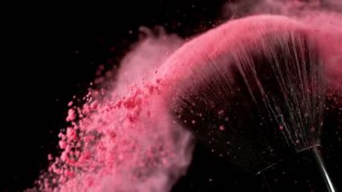 Düşen pembe tozlu, siyah arkaplan makyajlı süper yavaş makyaj fırçası. Yüksek hızlı sinema kamerası, 1000fps.