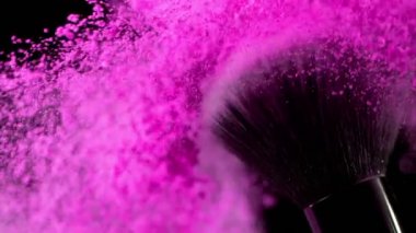Düşen pembe tozlu, siyah arkaplan makyajlı süper yavaş makyaj fırçası. Yüksek hızlı sinema kamerası, 1000fps.