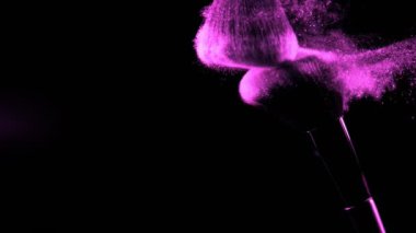 Düşen pembe tozlu, siyah arkaplan makyajlı süper yavaş makyaj fırçası. Yüksek hızlı sinema kamerası, 1000fps.