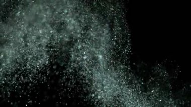 Siyah arka plan üzerine süper ışıltılı, yavaş gümüş parçacıkları. Odak sığ derinliği. Yüksek hız sinema kamerası, 1000 fps üzerinde filme.