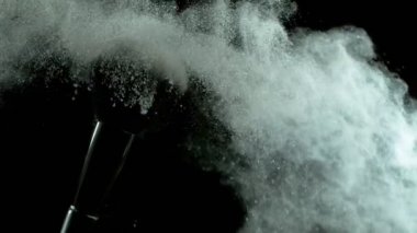 Düşen gümüş tozlu, siyah arkaplan makyajlı süper yavaş makyaj fırçası. Yüksek hızlı sinema kamerası, 1000fps.