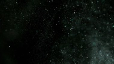 Siyah arka plan üzerine süper ışıltılı, yavaş gümüş parçacıkları. Odak sığ derinliği. Yüksek hız sinema kamerası, 1000 fps üzerinde filme.