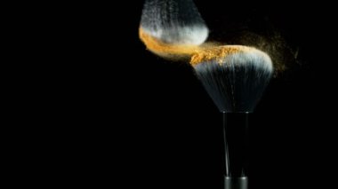 Makyaj fırçalarının düşme pudrası ve siyah arkaplanı çok yavaş. Yüksek hızlı sinema kamerası, 1000fps.