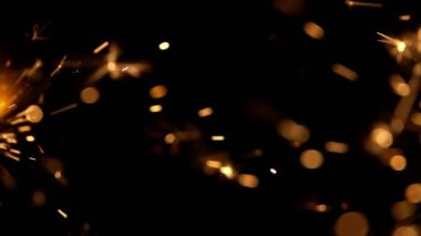 Siyah arka planda yanan kıvılcımların süper yavaş hareketi. Yüksek hızlı sinema kamera, 1000fps filme.