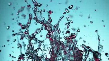 Yumuşak mavi arka planda patlayan suyun süper yavaş akışı. Yüksek hızlı sinema kamerası, 1000fps.