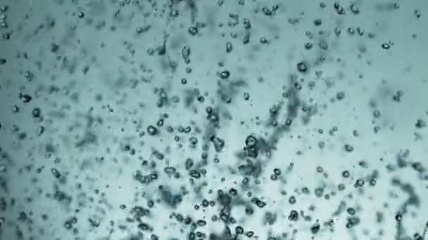 Mouvement super lent des éclaboussures d'eau volante sur fond bleu doux. Filmé sur caméra de cinéma à grande vitesse, 1000fps.