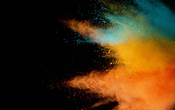 Explosion von farbigem Pulver isoliert auf schwarzem Hintergrund — Stockfoto