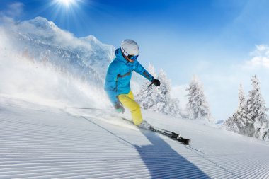 Alp Dağları'nda yamaç aşağı çalışan genç adam kayakçı