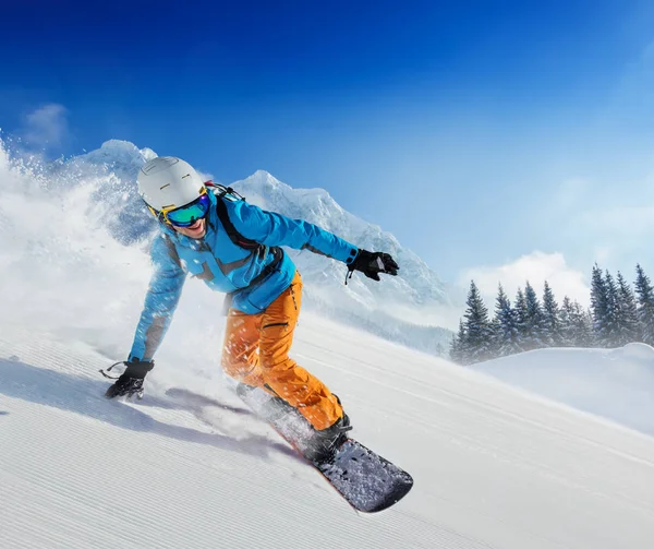 Jugendlicher Snowboarder rennt in alpiner Gebirgslandschaft den Hang hinunter — Stockfoto