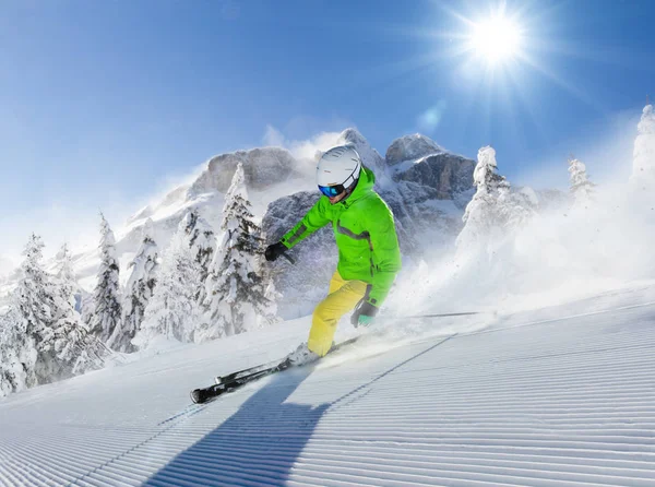 Ung man skidåkare kör ner backen i alpina berg — Stockfoto