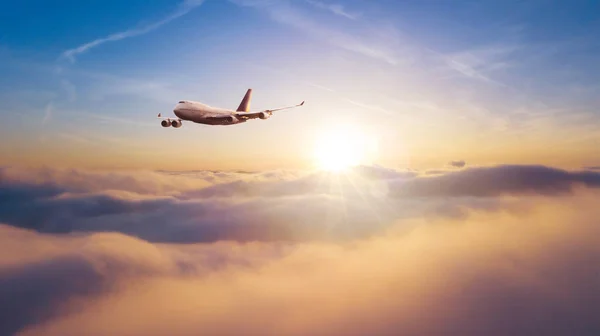 Commercial airplane flying over dramatic sunset — Stock Photo, Image