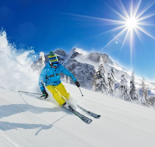 Young man skier running down the slope in Alpine mountains Royalty Free Stock Photos