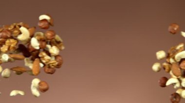 Uçan fındık karışımının süper yavaş çekimi. Yüksek hızlı sinema kamerası, 1000 fps..