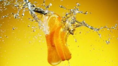 Süper yavaş çekimde portakal dilimleri su sıçramalarıyla çarpışır. Yüksek hızlı sinema kamerası, 1000 fps..