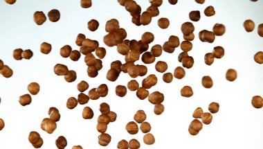 Beyaz arka planda uçan fındıkların gerçekçi dondurucu hareketi.