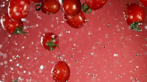 Super Langzame Beweging Van Vallende Tomaten Met Water Spatten Gefilmd — Stockvideo