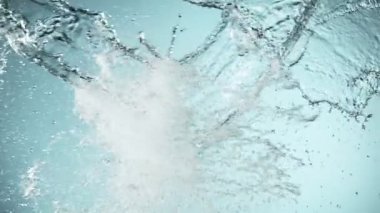 Uçan suyun süper yavaş akımı çarpışma halinde, mavi arka planda. Yüksek hızlı sinema kamerası, 1000fps.