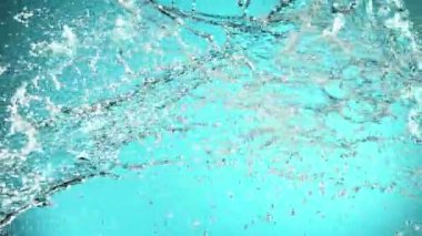 Uçan suyun süper yavaş akımı çarpışma halinde, mavi arka planda. Yüksek hızlı sinema kamerası, 1000fps.