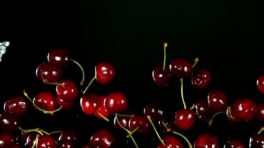 Su sıçramasıyla düşen kirazların süper yavaş çekimi. Yüksek hızlı sinema kamerası, 1000fps