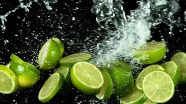 Su sıçramalarıyla havada uçan limon parçalarının süper yavaş çekimi. Yüksek hızlı sinema kamerası, 1000 fps..