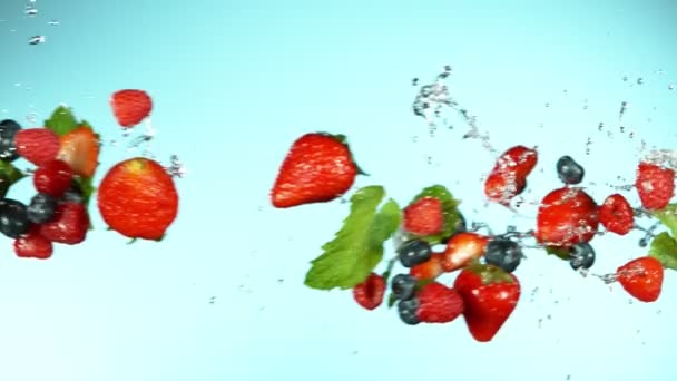 果実の超遅い動きは水の飛沫で空中を飛んでいます 高速フィルムカメラで撮影しました — ストック動画