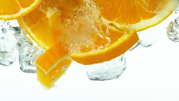 Супер Повільний Рух Падіння Апельсинових Скибочок Кубиків Льоду Розбризкування Води — стокове відео