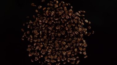 Siyah arka planda kahve çekirdeklerini döndürmek için süper yavaş çekim. Yüksek hızlı sinema kamerası, 1000 fps..