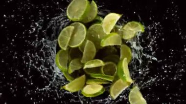 Suda dönen limon dilimlerinin süper yavaş çekimi, siyah arka plan. Yüksek hızlı sinema kamerası, 1000 fps..