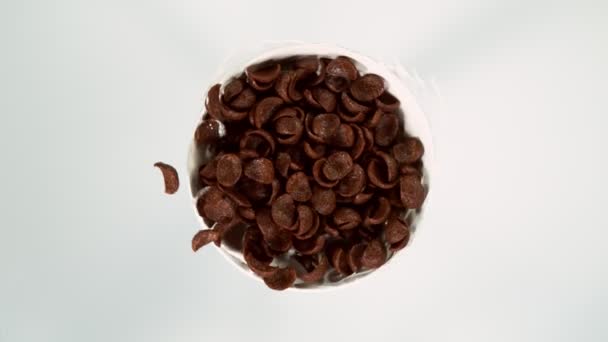 Movimento Super Lento Pedaços Chocolate Cereais Rotativos Com Salpicos Leite — Vídeo de Stock