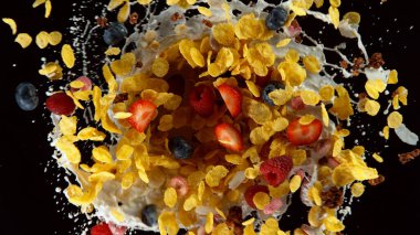 Siyah arka planda izole edilmiş, süt sıçramalı gevrek parçalarının hareketsiz hareketi. Uçan yemek konsepti, sağlıklı yemek..