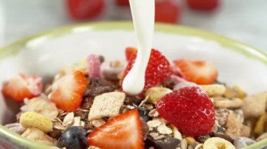 Mısır gevreğiyle dolu kaseye süt dökmenin süper yavaş çekimi, kamera hareketi. Yüksek hızlı sinema kamerası, 1000fps.