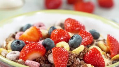 Mısır gevreğiyle dolu kaseye süt dökmenin süper yavaş çekimi, kamera hareketi. Yüksek hızlı sinema kamerası, 1000fps.